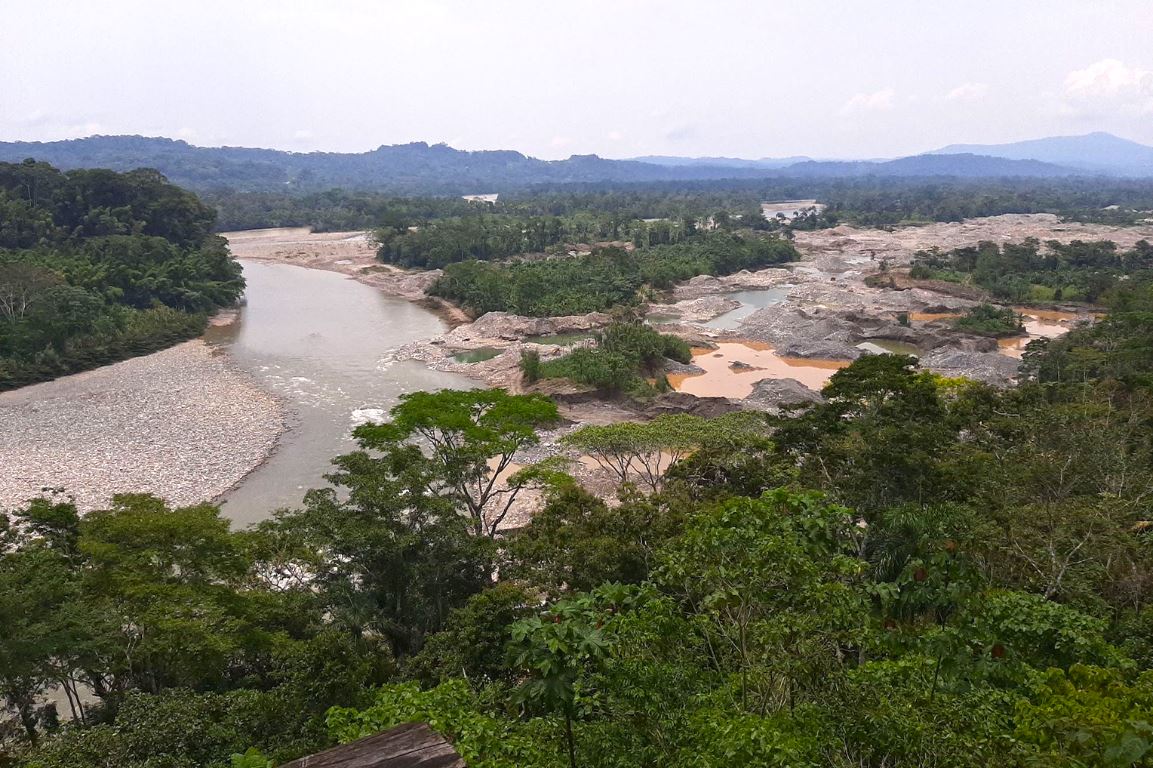Deforested area and illegal mining activity along a river in the Amazon rainforest causing environmental destruction and land degradation.
