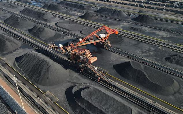 Aerial view of coal stockpiles and industrial loading machinery at a large coal transportation and storage facility in China.