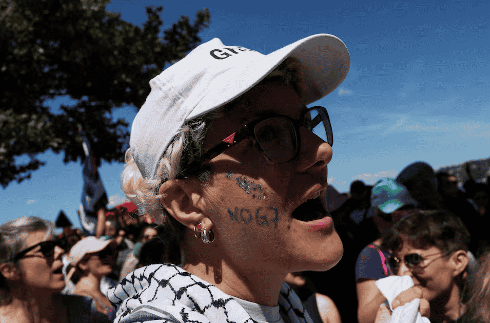 Anti-G7 protester with "No G7" painted on their face attends a demonstration in Geneva ahead of the G7 summit in France.