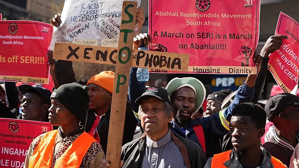 Protesters in South Africa hold anti-xenophobia signs during a demonstration against migrant discrimination