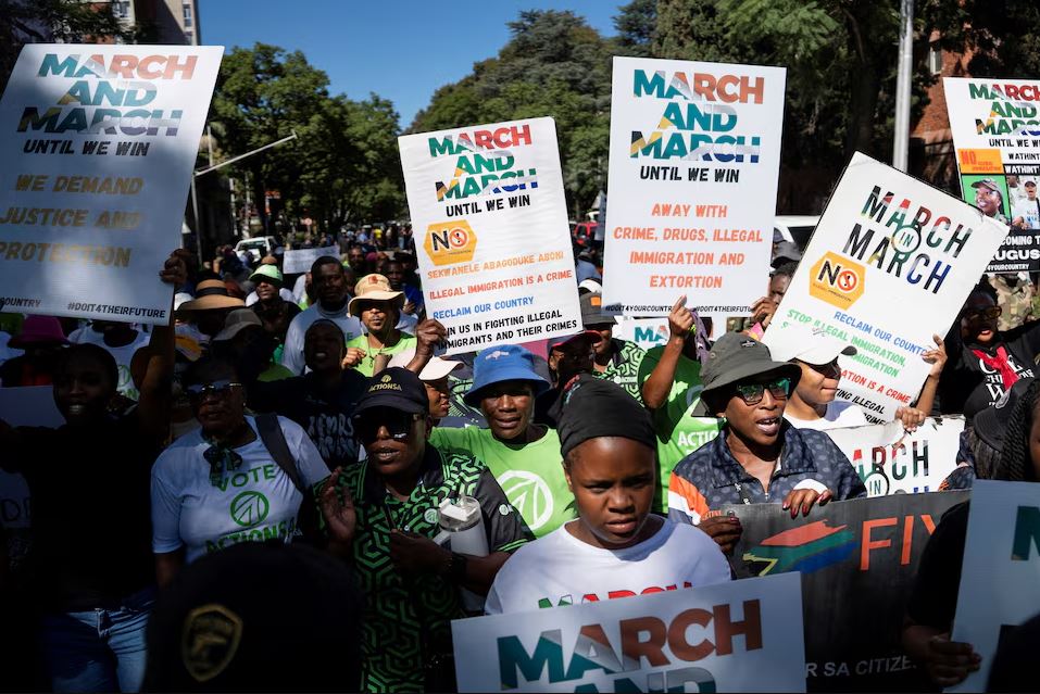 Protesters march in South Africa holding anti-illegal immigration placards amid rising tensions and xenophobic attacks targeting foreign nationals.