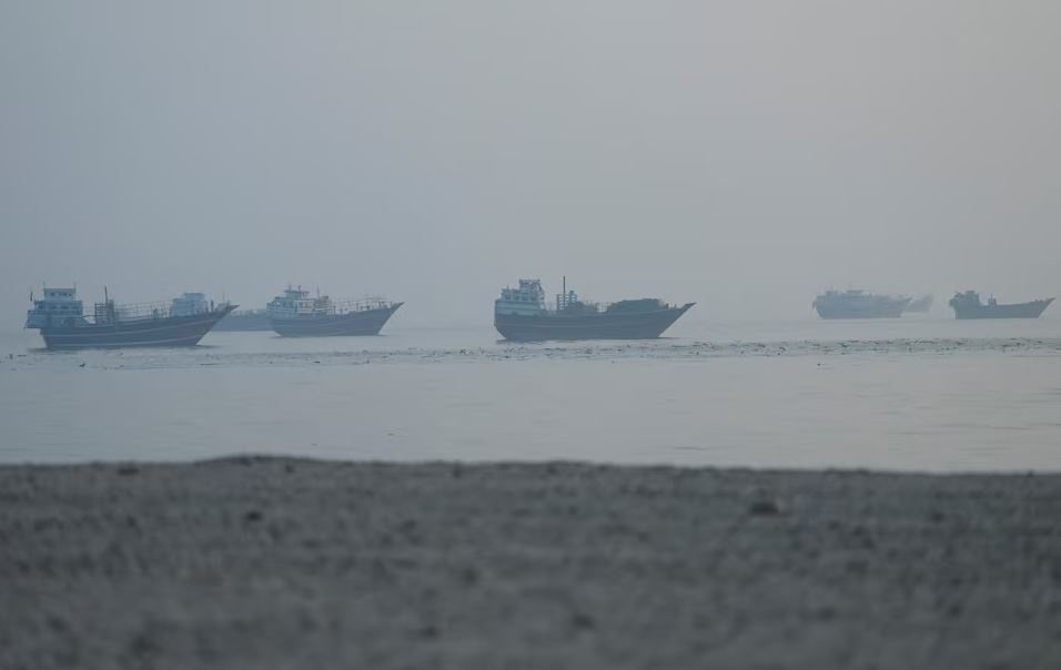 Cargo and oil vessels sail through hazy waters near the Strait of Hormuz, a critical global energy shipping route affected by the Iran-US peace agreement.