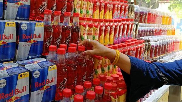Store shelf stocked with Red Bull, Sting, and other energy drink bottles during FSSAI's labeling review in India.