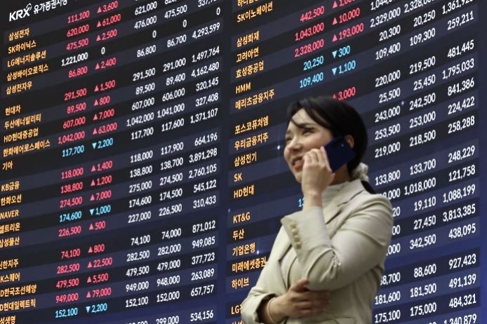 Investor standing before a KRX stock board showing falling Samsung Electronics and SK Hynix share prices during the KOSPI market sell-off.