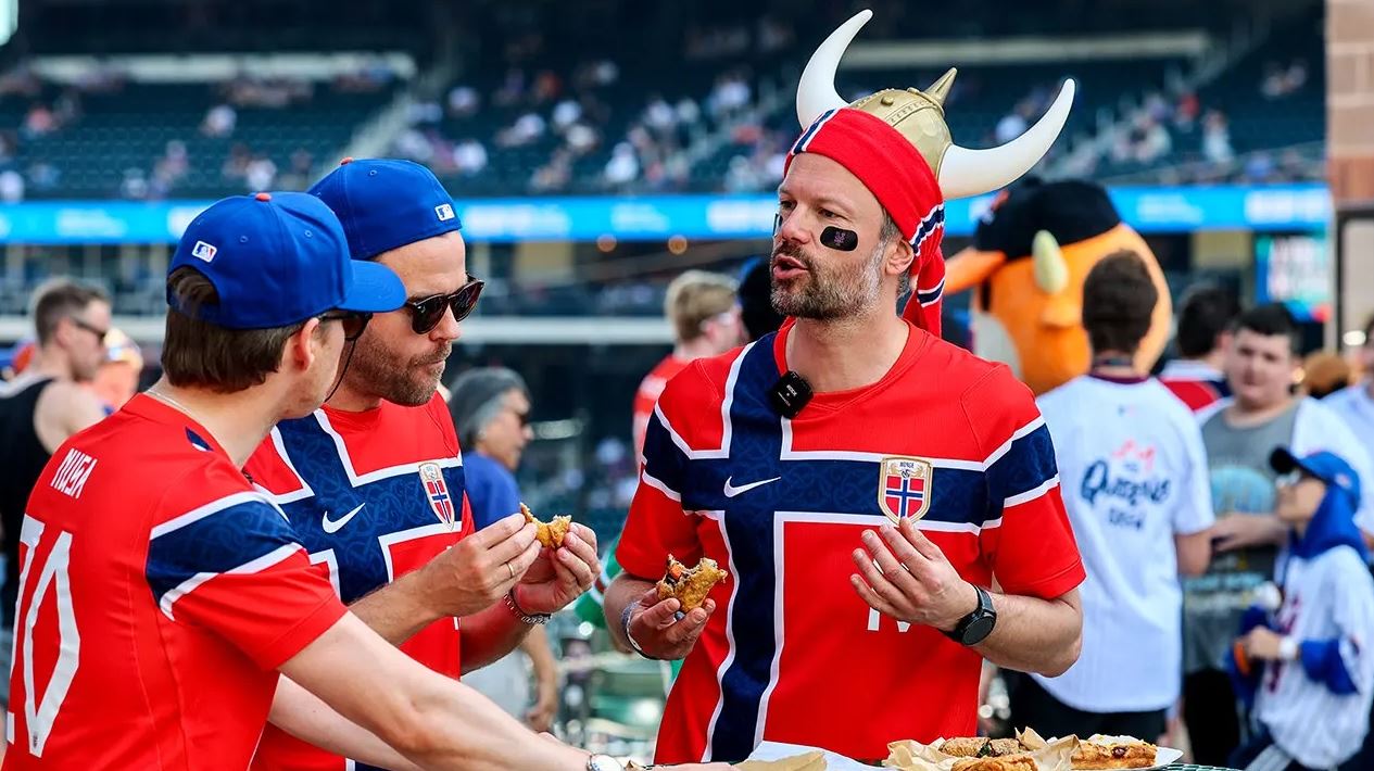 Norwegian World Cup supporters wearing national team jerseys and Viking helmets gather at Citi Field during a New York Mets game.