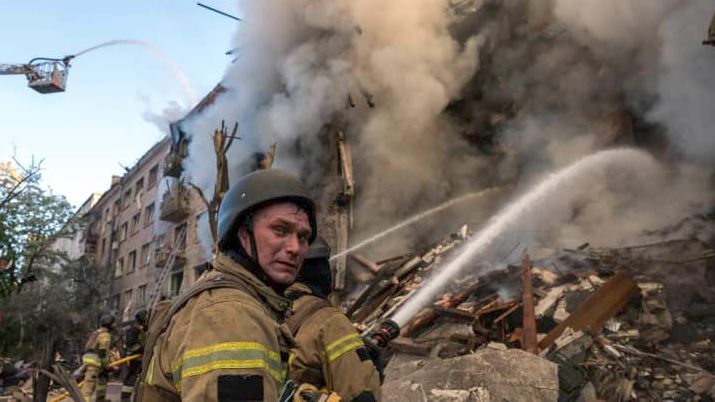 Burning residential building in Kyiv after Russian missile and drone attack as firefighters battle heavy smoke and debris amid the ongoing Ukraine war.