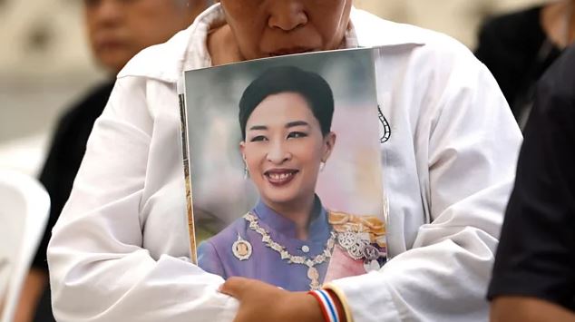 Mourner holding a portrait of Princess Bajrakitiyabha at a memorial event following her death in Thailand.