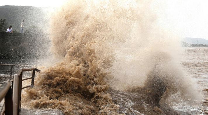 Massive waves from Typhoon Bavi crash into a coastal seawall during severe storm conditions in East Asia.