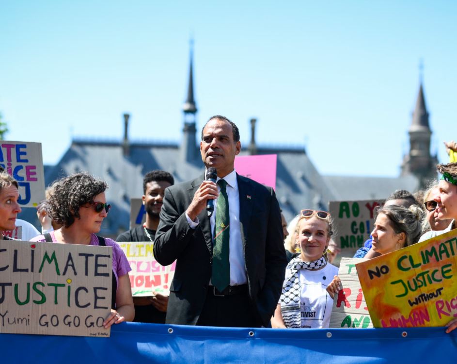 Climate activists gather during a climate justice rally as a speaker addresses protesters ahead of the UN vote on the ICJ climate accountability resolution.